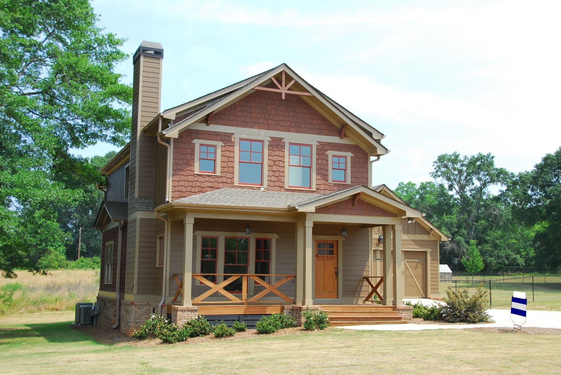A craftsman house with cedar shake gables and stained wood siding in clear daylight