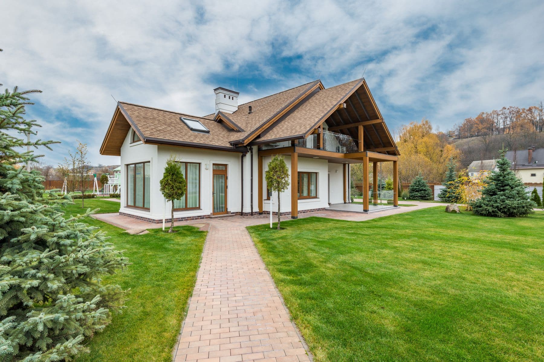 A house with heavy timber posts, stained wood frames, and a deep roof overhang